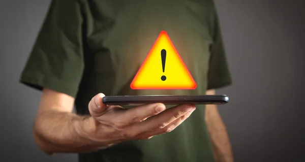Man holding smartphone. System hacked warning alert