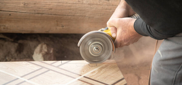 Работник резки керамической плитки с мельницей.