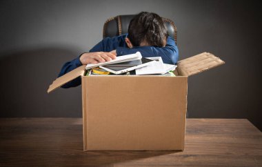 Elinde karton kutu ve iş eşyaları olan bir iş adamı. İş kaybı. İşsizlik Kurumu