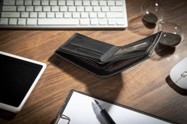 Boş cüzdan ve ahşap masada bir iş eşyası..