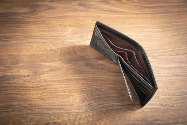 Empty wallet on the wooden table.