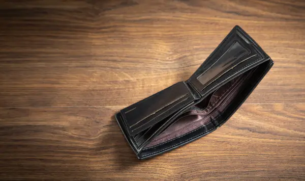 Empty wallet on the wooden table.