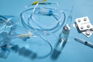  Enfüzyon torbası, şırınga, mavi arka planda tıbbi ampuller. Damlama odası