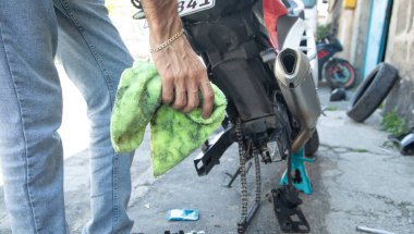 Motosikletli adam motosikleti temizliyor. Bakım, tamir motosikleti