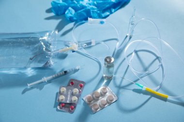  Enfüzyon torbası, şırınga, mavi arka planda tıbbi ampuller. Damlama odası