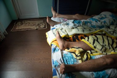 Yatakta insan bacakları. Yaşam biçimi