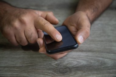 Elinde siyah akıllı telefon tutan kişi. Teknoloji. Yaşam biçimi