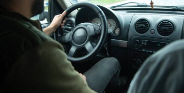 Dışarıda arabasını süren bir adam var..