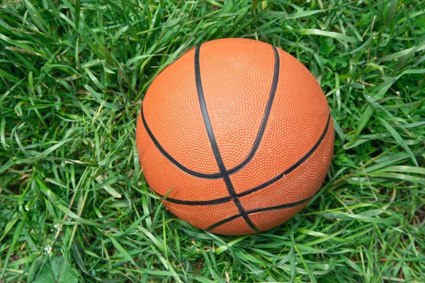 Basketball ball on the green grass background.