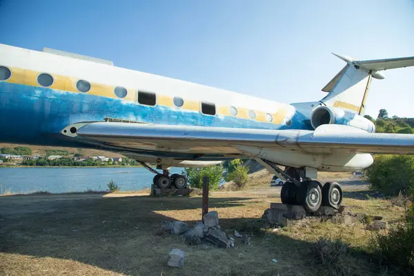 Açık havada terk edilmiş eski bir uçağın görüntüsü.