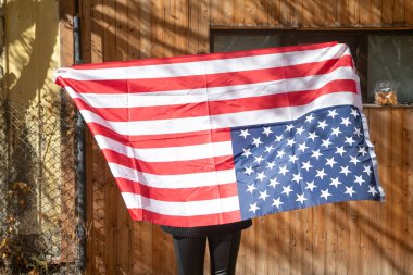 Amerikan bayrağı taşıyan beyaz bir kadın..