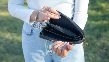 Boş cüzdan gösteren genç bir kadın. Kriz