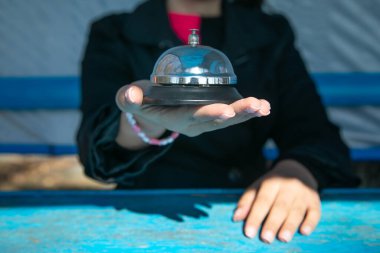 Kadın masadaki servis zilini çalıyor..