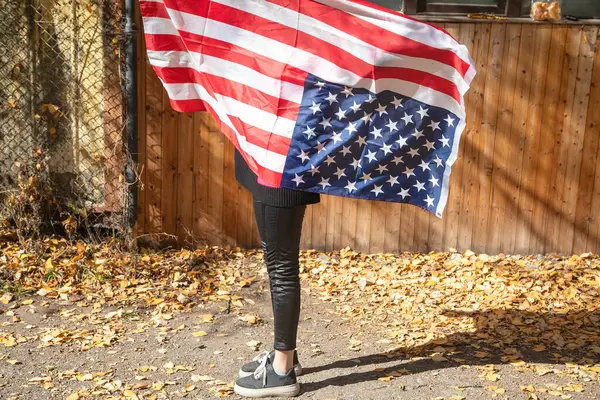 Amerikan bayrağı taşıyan beyaz bir kadın..