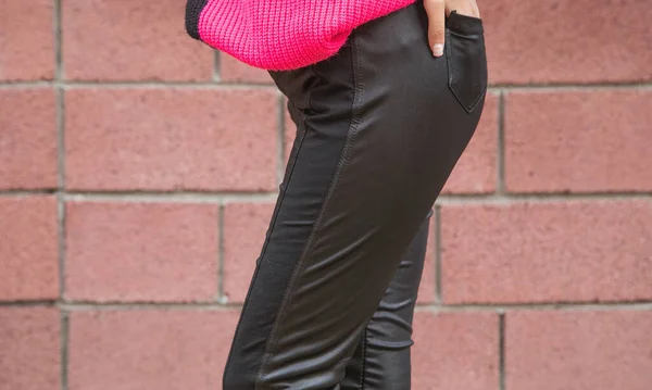 Young girl in a black leather pants.