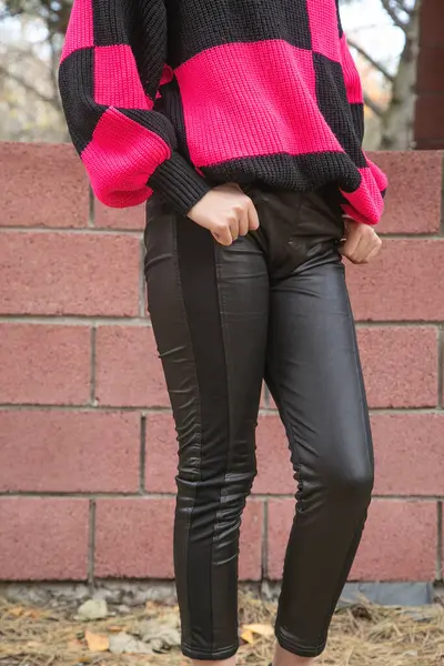 Young girl in a black leather pants.