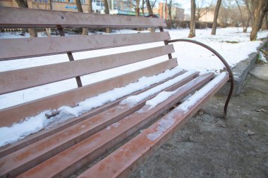 Kış parkında bankta kar.