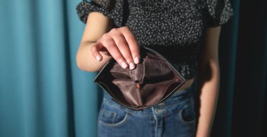 Boş cüzdan gösteren genç bir kadın. Kriz