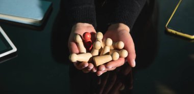 Tahta insan figürleri gösteren bir kadın. Adam alımı. Liderlik