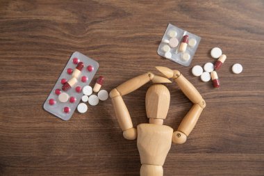 Tıbbi hapları olan tahta insan figürü..