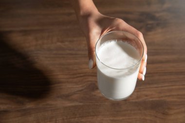 Elin masada bir bardak süt tutuyor..