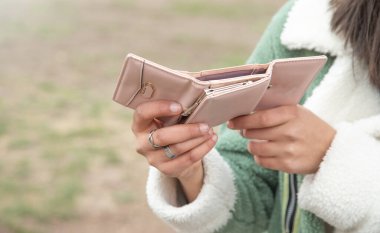 Young woman showing wallet. Fashion