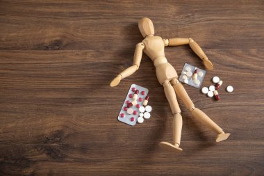 Tıbbi hapları olan tahta insan figürü..