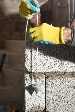 Eski ölçüm aracı üzerinde işçiler beton duvar ölçer.