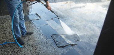 İstasyonda lastik araba paspası yıkayan bir işçi..  