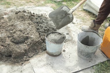 İnşaat alanında beton karıştıran işçiler.