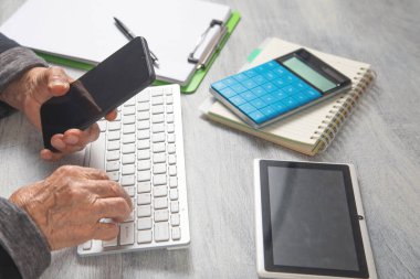 Akıllı telefon kullanan yaşlı kadının elleri.