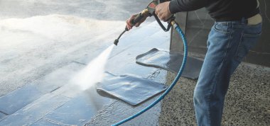 İstasyonda lastik araba paspası yıkayan bir işçi..  