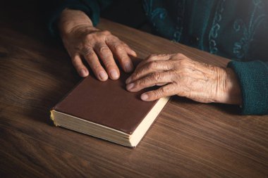 Kafkasyalı yaşlı kadın İncil 'i tutuyor..