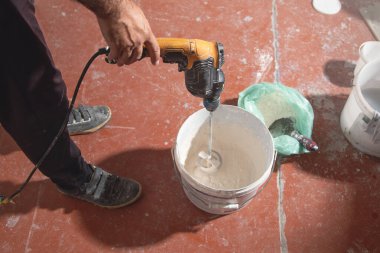 İşçi, alçı taşını kovada karıştırır..