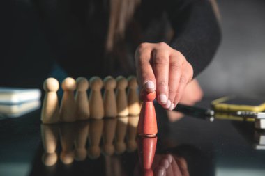 Tahta insan figürleri gösteren bir kadın. Adam alımı. Liderlik