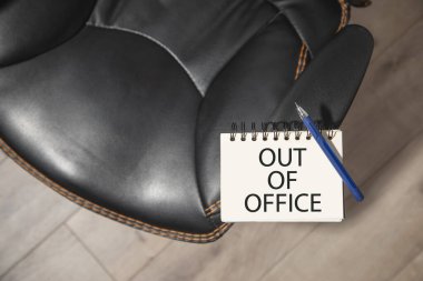 Ofis dışı mesajı bir ofis sandalyesi ile not defterine..
