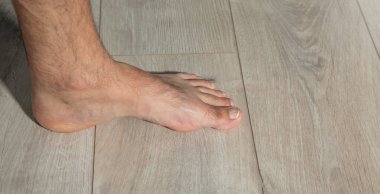 Kaplamalı zeminde yalınayak bir erkek..