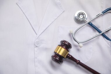 Doktor kıyafetlerini steteskopla inceleyen Yargıç Gavin..