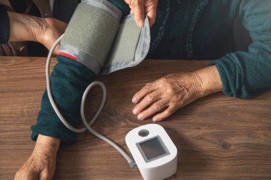 Evde yaşlı bir kadının tansiyonunu ölçüyorum..