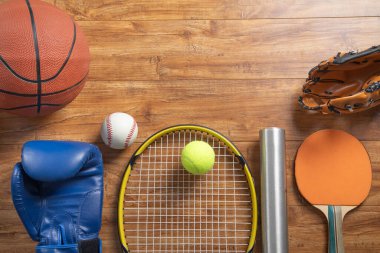 Ahşap arka planda çeşitli spor ekipmanları.