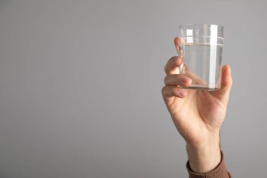 Beyaz adam bir bardak su gösteriyor..