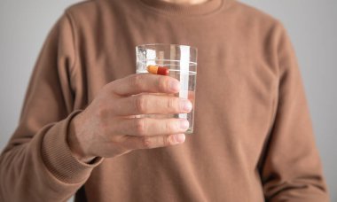 Beyaz adam bir bardak su gösteriyor..