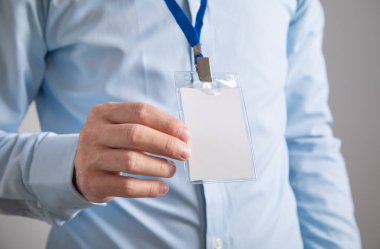 Plastik boş rozet gösteren bir iş adamı.