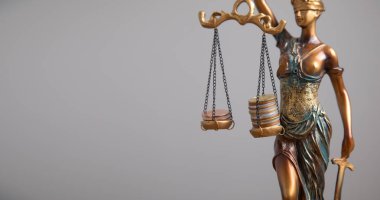 Adalet Anıtı heykeli bozuk para yığınlarını dengeliyor. Hukuk