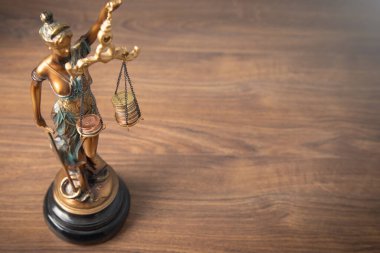 Adalet Anıtı heykeli bozuk para yığınlarını dengeliyor. Hukuk