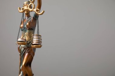 Adalet Anıtı heykeli bozuk para yığınlarını dengeliyor. Hukuk