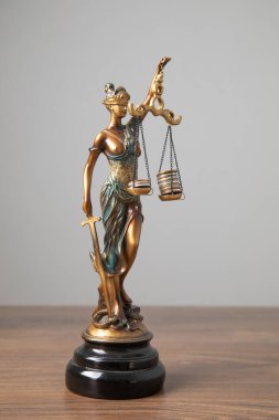 Adalet Anıtı heykeli bozuk para yığınlarını dengeliyor. Hukuk