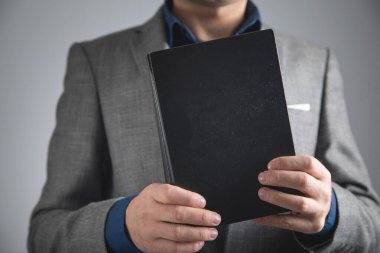 Avukat ya da yargıç elinde kitap tutuyor..