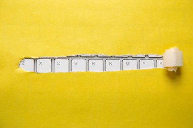 Bilgisayar klavyeli yırtık bir kağıt.