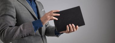 Avukat ya da yargıç elinde kitap tutuyor..